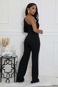 Détail d'une combinaison noire moulante à une épaule avec manche asymétrique et jambe évasée