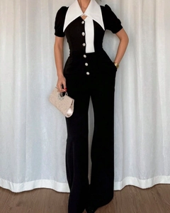 Detail of elegant black and white patchwork sleeveless jumpsuit with retro collar and buttons