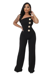 Detail of black strapless jumpsuit featuring decorative large gold buttons and slim fit cut