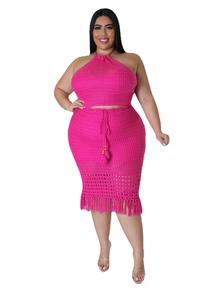 Detail of fuchsia knit two-piece set featuring hollow mesh pattern and long fringe hem