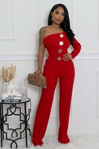 Détail d'une combinaison rouge asymétrique avec de gros boutons métalliques dorés