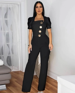 Detail showing vintage bubble sleeves and four large golden embossed buttons on black jumpsuit