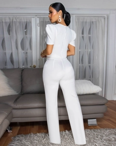 Detail of elegant white jumpsuit featuring puff sleeves and hidden back zipper closure