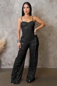 Detail of faux leather wide-leg jumpsuit with metallic gold buttons and thin straps