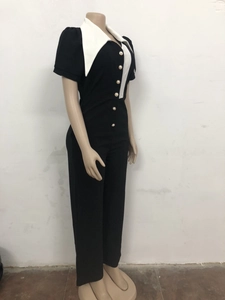 Detail view of contrast black and white jumpsuit featuring a large pointed collar and buttons