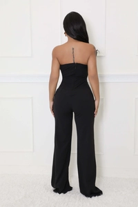 Rear view of black strapless jumpsuit featuring a high waist and hidden back zipper detail
