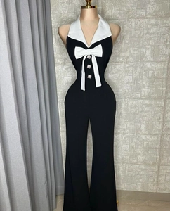 Detailansicht des schwarzen Jumpsuits mit weißem Matrosenkragen und dekorativen Perlenknöpfen