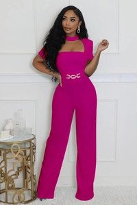 Détail d'une élégante combinaison fuchsia à jambes larges avec décolleté ajouré et chaîne dorée