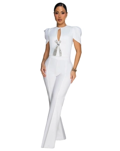 Detail of white jumpsuit featuring rhinestone bow, keyhole neckline and puff sleeves