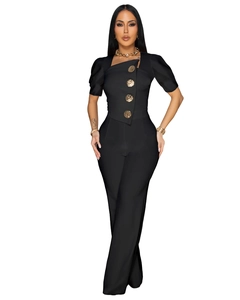 Detail of square neck black jumpsuit featuring four decorative gold embossed buttons