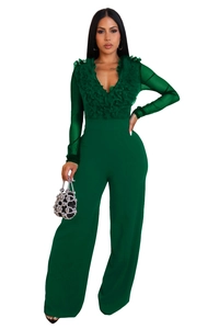 Detail of dark green jumpsuit showing deep V-neck, ruffle decor and sheer mesh sleeves