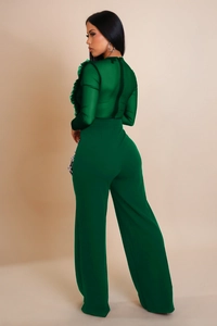 Detail of emerald green mesh patchwork jumpsuit with pleated ruffles on shoulders and neckline