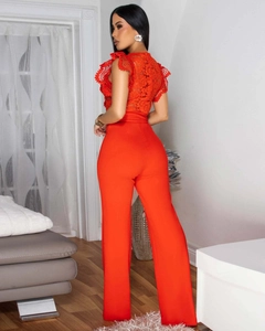 Detail of red floral lace stitching and ruffled shoulder on sleeveless jumpsuit