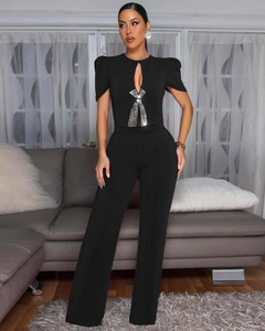 Detail of black wide-leg jumpsuit featuring silver rhinestone fringe and hollow neckline