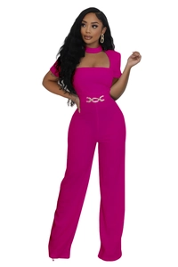 Détail d'une élégante combinaison magenta à jambes larges avec une chaîne de taille dorée