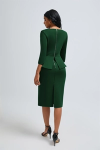 Détail du dos d'une robe péplum vert foncé avec une longue fermeture éclair en métal argenté