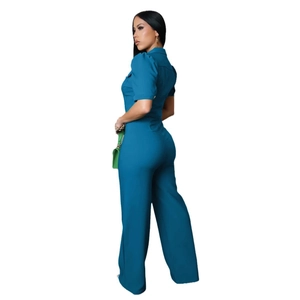 Detail view of teal blue short sleeve jumpsuit with lapel collar and waist-cinching design