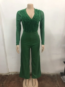 Detail of green mesh long sleeve jumpsuit featuring V-neck and layered ruffle trim