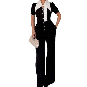 Sleeveless black and white patchwork bodysuit with wide collar and white stripe details