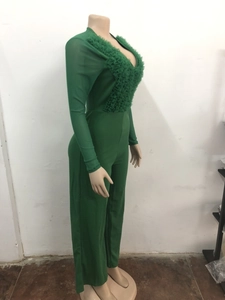 Detail of dark green jumpsuit featuring mesh panels and pleated chest decoration