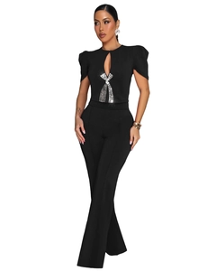 Close-up of sparkling rhinestone bow and teardrop cutout on black short sleeve jumpsuit