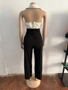 Dettaglio di una tuta all'americana con top in tweed e pantaloni larghi a vita alta