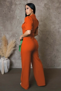 Side view of fitted orange short sleeve jumpsuit with lapel collar and metal button details