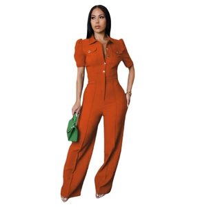 Detail of orange short-sleeve jumpsuit with lapel collar and gold button pockets
