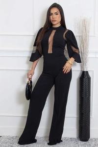 Détail d'une élégante combinaison noire à jambes larges avec patchwork en tulle fin