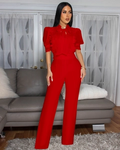 Details des roten eleganten Jumpsuits mit Spitzenpatchwork und Schleife am Ausschnitt