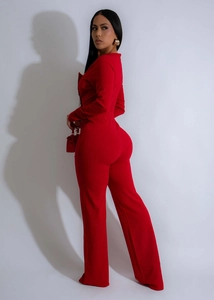 Vista laterale della tuta rossa a maniche lunghe con vita definita e pantaloni a gamba larga