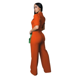 Detail view showing the bright orange short sleeve jumpsuit with tailored lapel design