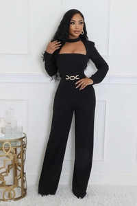 Detail of elegant black long sleeve jumpsuit with cutout neckline and gold waist chain