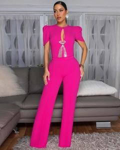Detail of fuchsia jumpsuit featuring a keyhole cutout and rhinestone bow accessory