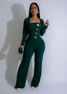 Dettaglio della tuta verde scuro con scollo a quadrato e grandi bottoni dorati decorativi