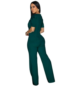 Detail showing the side view of the dark green short sleeve jumpsuit with tailored waist line