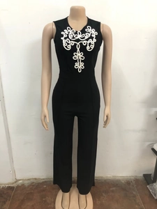 Détail de la broderie à nœud blanc sur la poitrine d'une combinaison noire sans manches