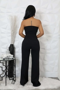 Rear view of strapless black wide-leg jumpsuit showing back zipper detail and slim fit cut