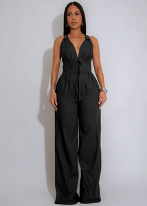 Detail of black halter deep V jumpsuit featuring drawstring waist and metal shoulder eyelets