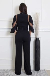 Détail d'une élégante combinaison noire avec manches en tulle et fermeture éclair dos