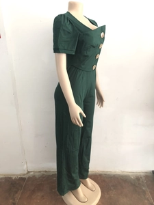 Detail view of large golden buttons and collar design on a dark green short sleeve jumpsuit