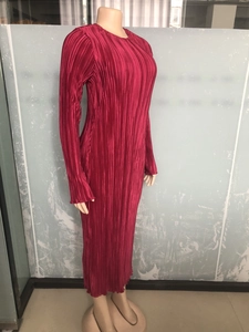 Detail of the high-stretch vertical pleated fabric on a long magenta maxi dress