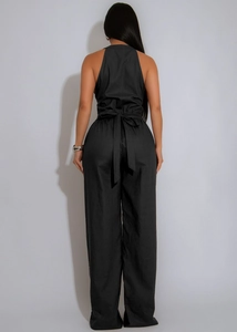 Back view of black halter neck jumpsuit with tie-waist bow and wide leg cut
