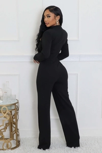Detail view of a black long sleeve wide leg jumpsuit with elegant back line design