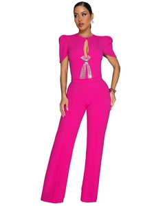 Close-up of sparkling rhinestone bow detail on a hot pink wide-leg jumpsuit