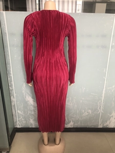Detail of rose red pleated stretch maxi dress showing fabric texture and long sleeves