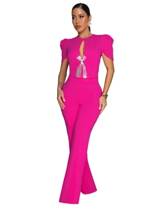 Detail of fuchsia jumpsuit featuring a teardrop cutout and rhinestone bow decoration