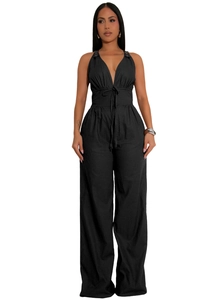 Detail of black sleeveless halter jumpsuit featuring a deep V-neck and drawstring waist