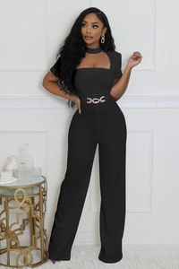 Détail d'une combinaison noire avec encolure licou ajourée et ceinture chaîne dorée