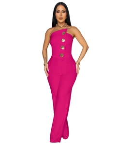 Detail of fuchsia one-shoulder jumpsuit featuring decorative gold embossed buttons on bodice